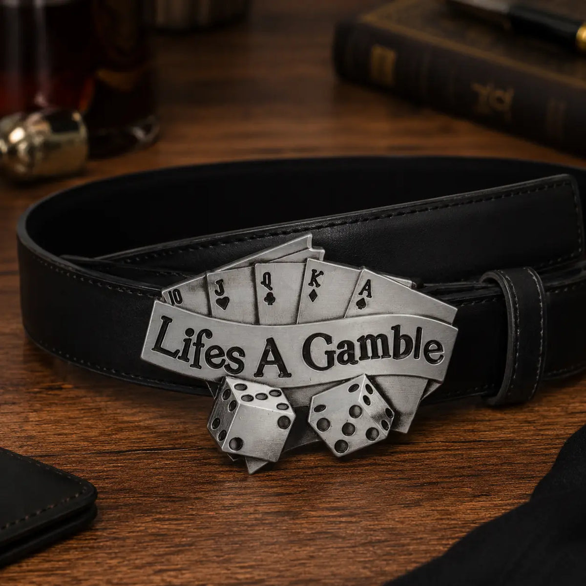 Black belt with a decorative buckle featuring playing card symbols and dice on a wooden surface.