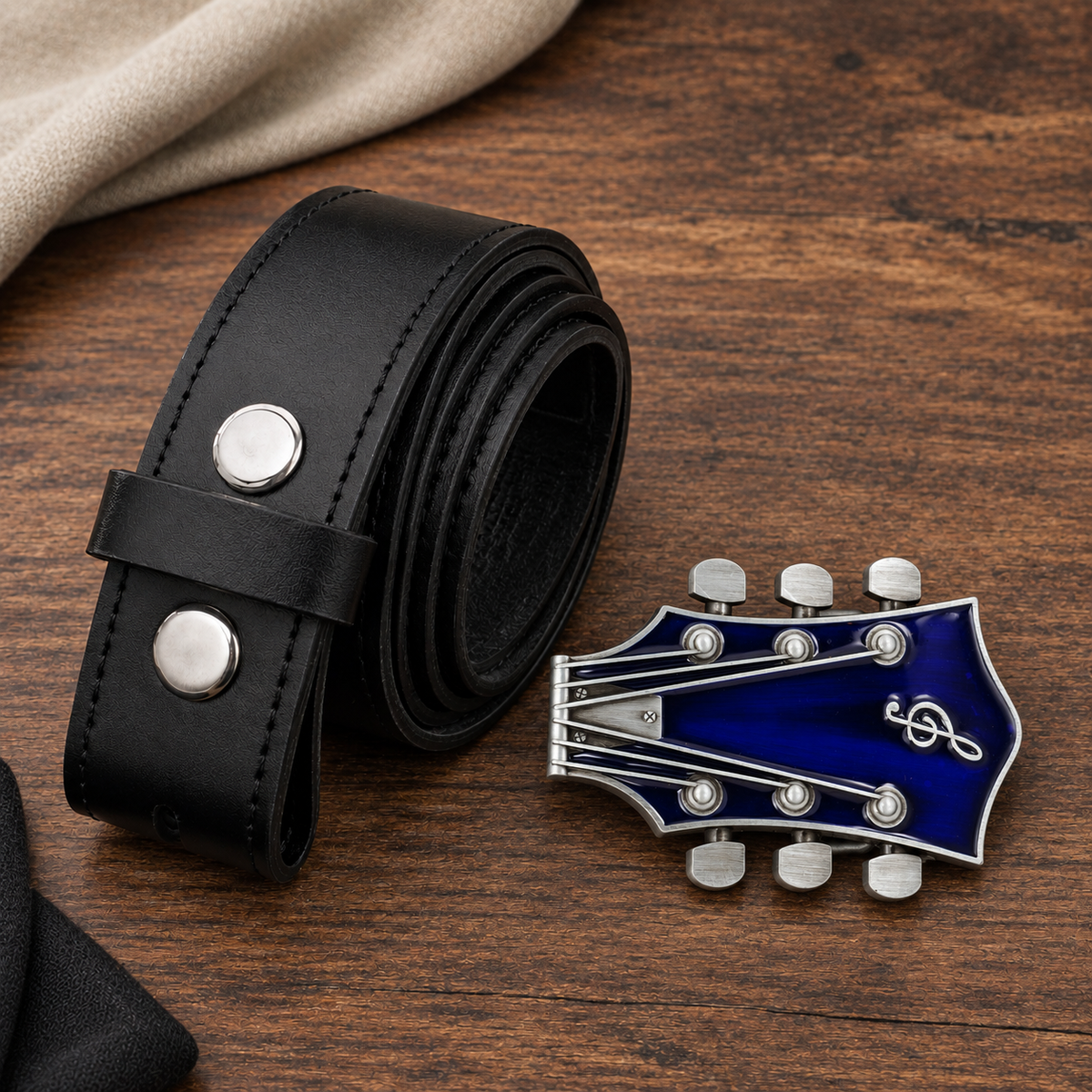 Deep blue guitar headstock buckle beside black 38 mm leather belt