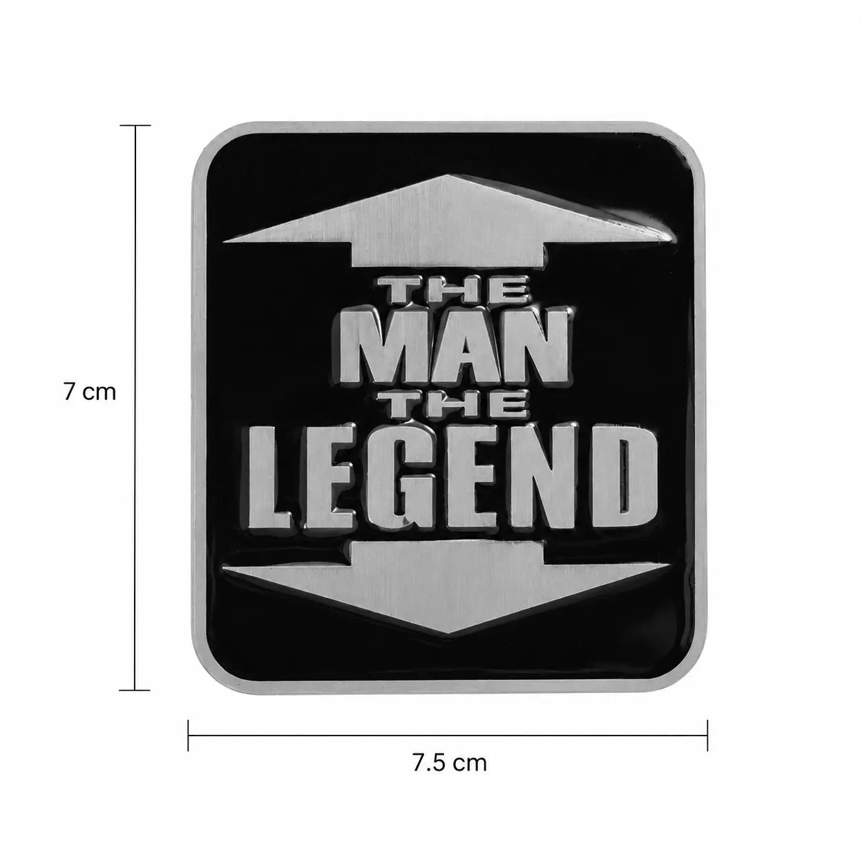A square black belt buckle with rounded corners, featuring the phrase “THE MAN THE LEGEND” in large metallic silver letters with arrow-like shapes above and below. White dimension lines and text show 7 cm height and 7.5cm
