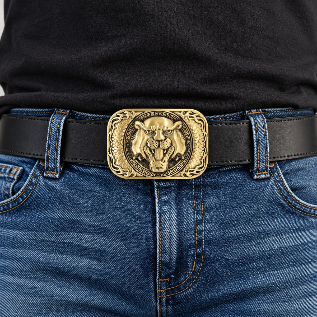 Antique gold tiger head belt buckle worn on a black mans leather belt