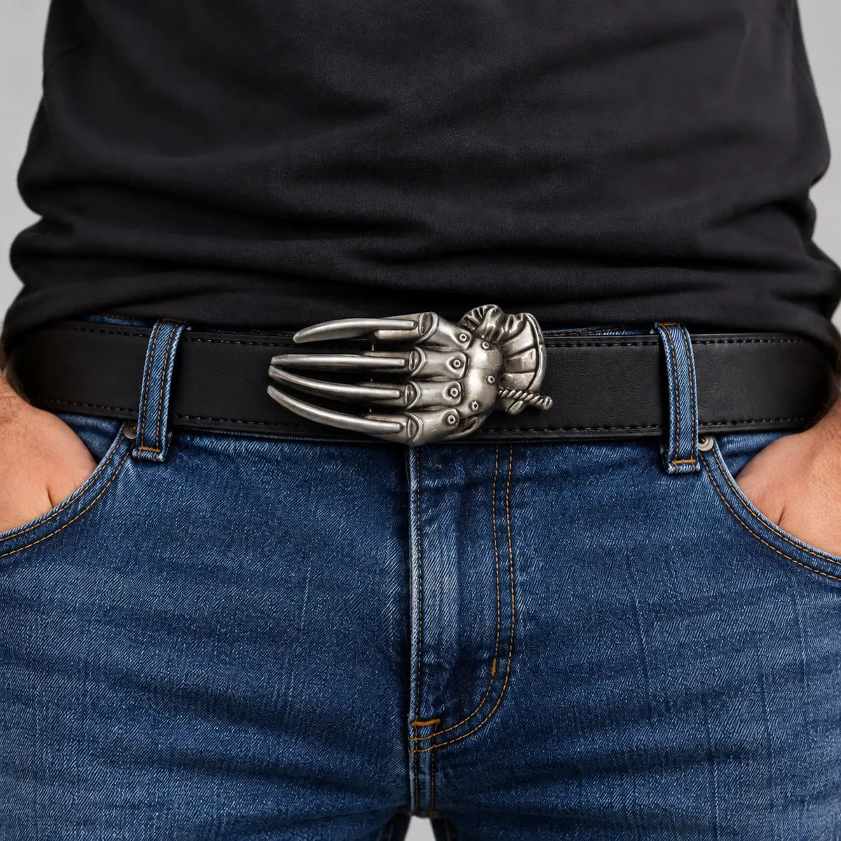 Razor glove belt buckle worn on a black leather belt, male model