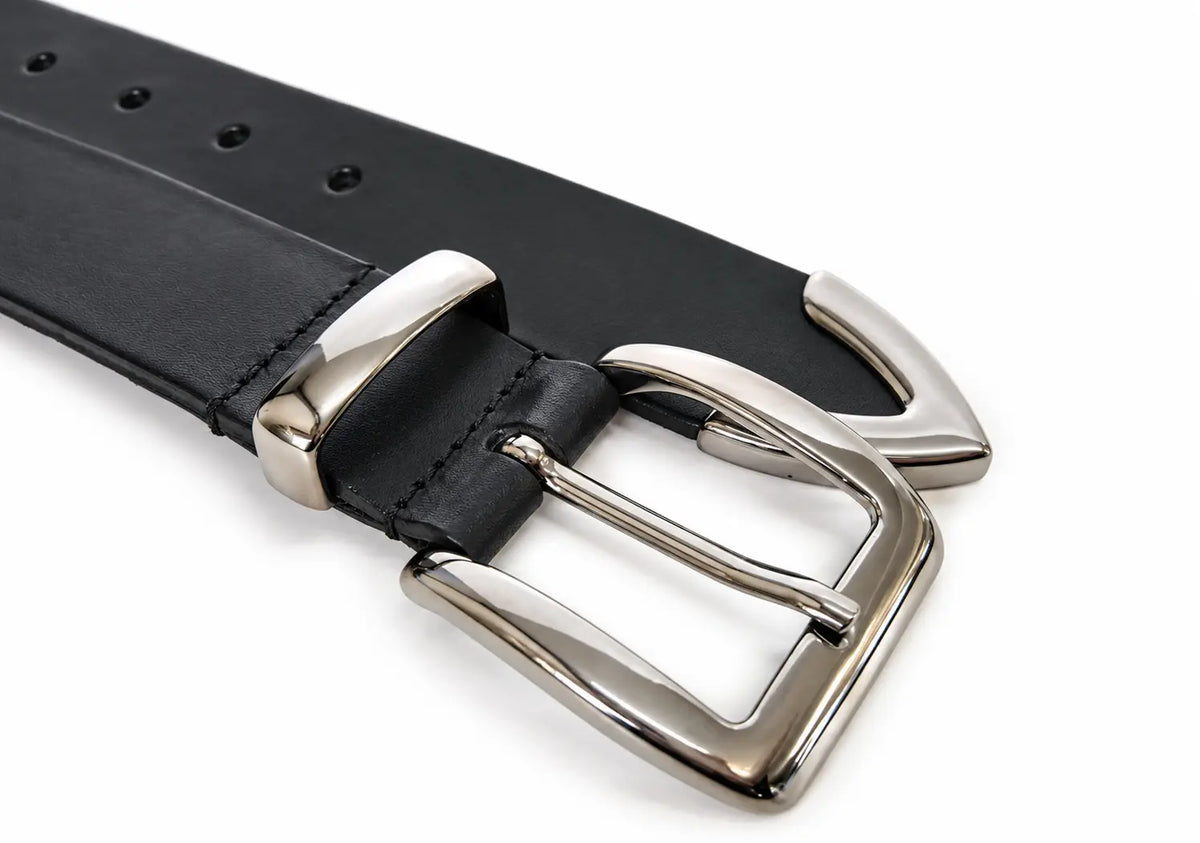 A close-up of a black leather belt with a polished silver-tone metal buckle and metal tip, set against a plain white background.