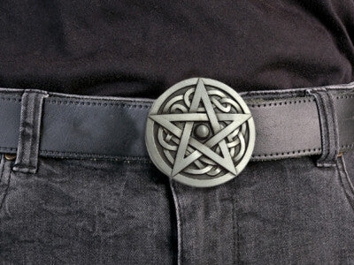 Metallic pentagram belt buckle with intricate designs on a black leather belt