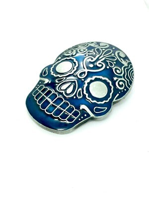 Blue day of the dead skull belt buckle with white patterns on a white background