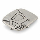 Angled view of silver cutaway skull belt buckle showing raised metal detailing