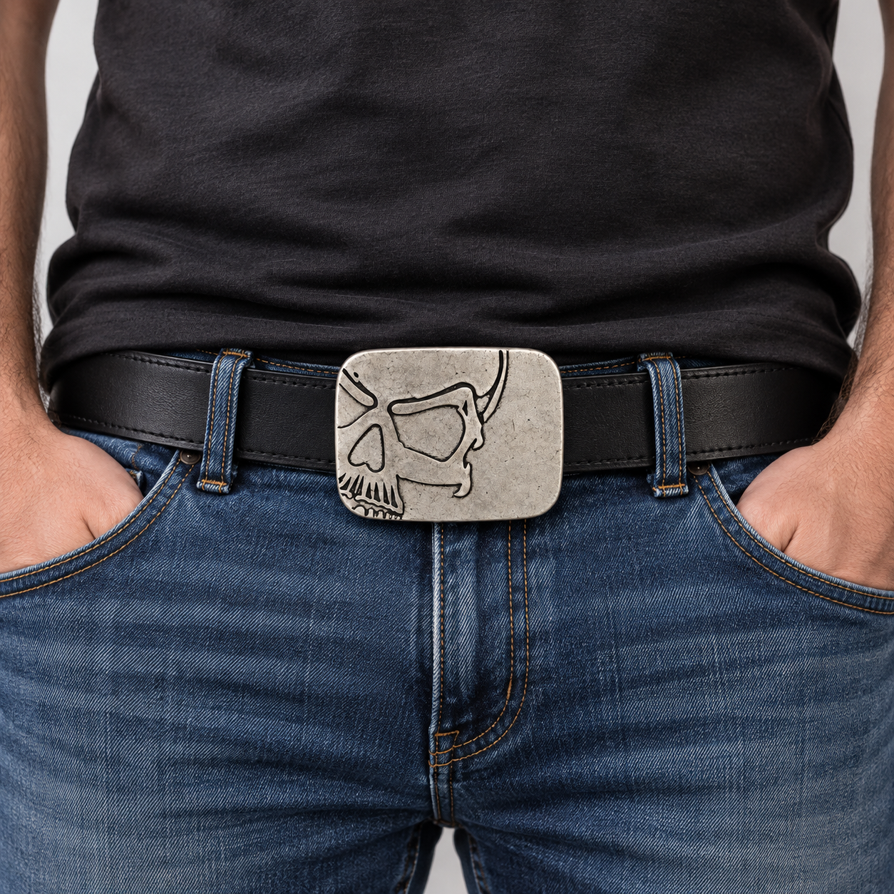 Silver cutaway skull belt buckle worn by a man on a black leather belt