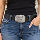 Silver cutaway skull belt buckle worn by a woman on a black leather belt