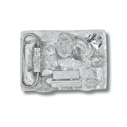 Silver belt buckle with detailed design on a white background