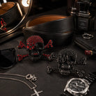 Black leather belt, skull belt buckles sunglasses, and watch on a dark surface