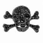 Black skull and crossbones belt buckle with embedded stones on a white background