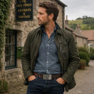 Man wearing celtic cross belt buckle standing in front of a stone building with 'The Old Forge Antiques & Vintage' sign.