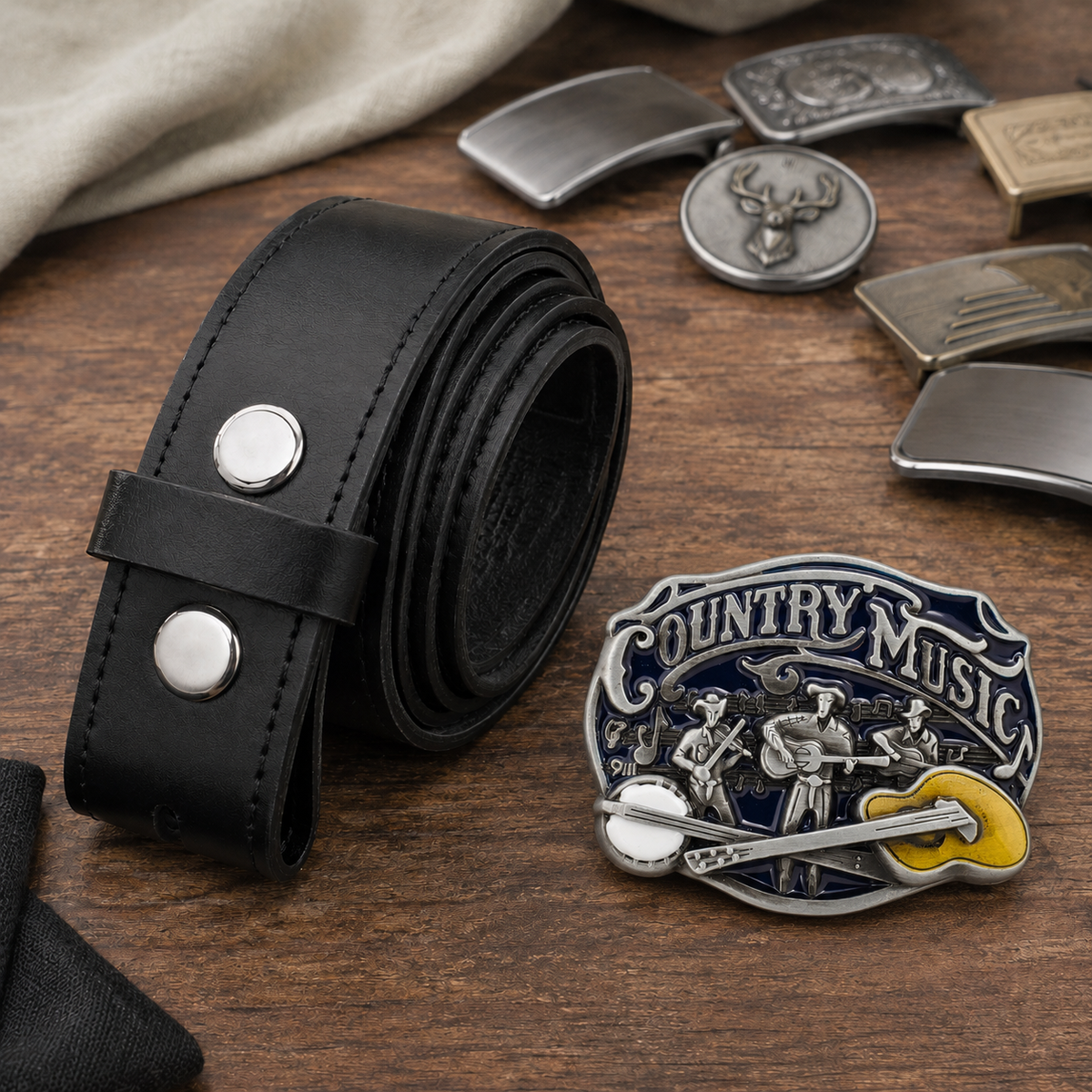 Country Music belt buckle beside a rolled black 38 mm leather buckle belt