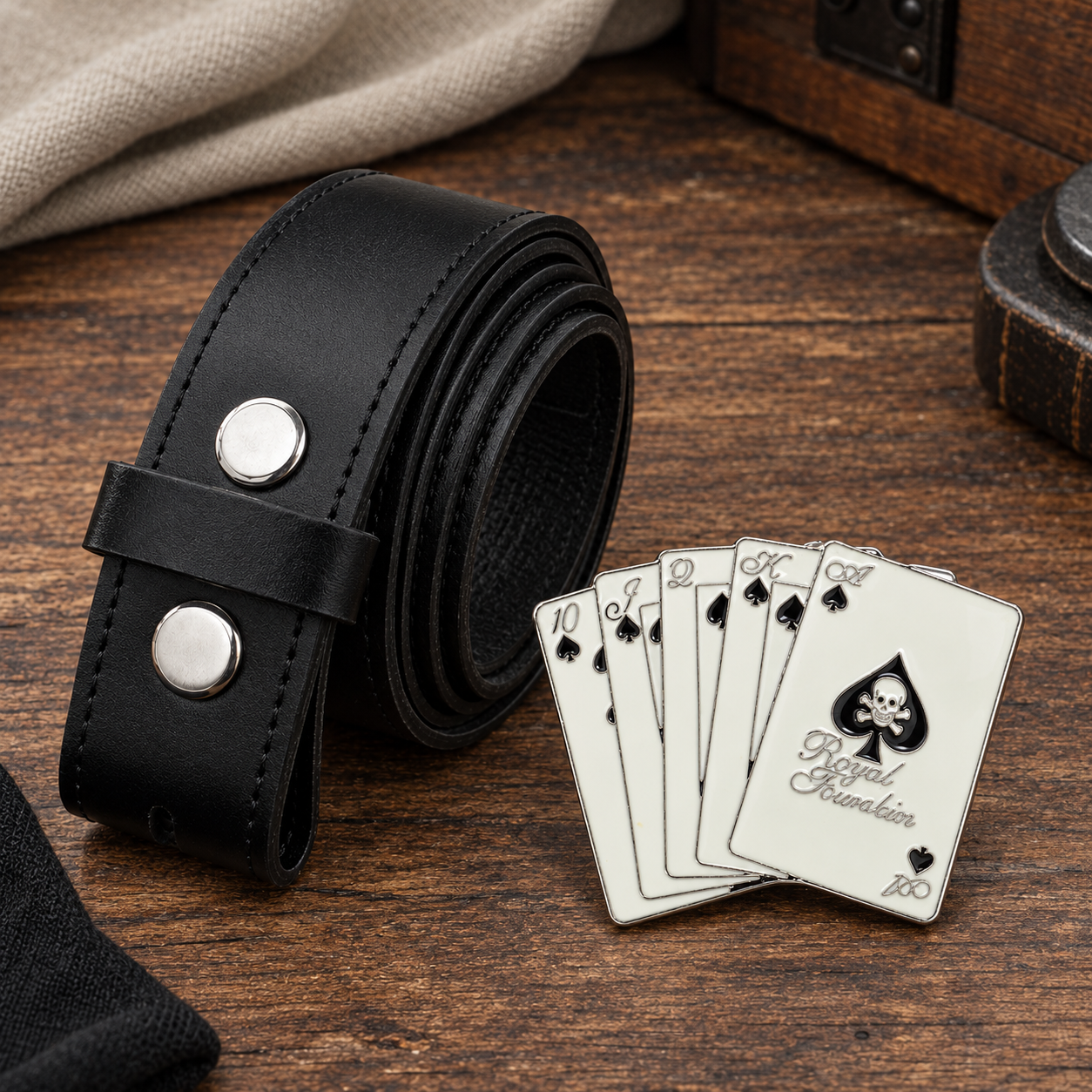 Royal Flush belt buckle beside rolled black leather interchangeable buckle belt