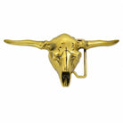 A gold-toned metal belt buckle shaped like a longhorn steer skull, featuring long curved horns and a hidden fastening bar on the right side, shown against a plain white background.