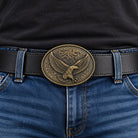 Antique bronze flying eagle belt buckle worn on a black mans leather belt