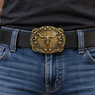 Antique bronze longhorn skull belt buckle worn on a black leather belt