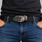 Razor glove belt buckle worn on a black leather belt, male model