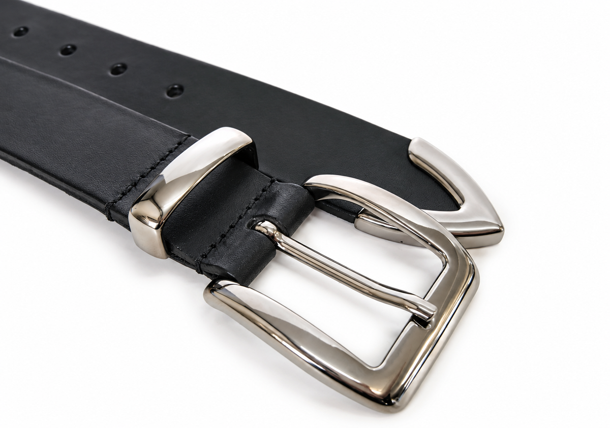 A close-up of a black leather belt with a polished silver-tone metal buckle and metal tip, set against a plain white background.